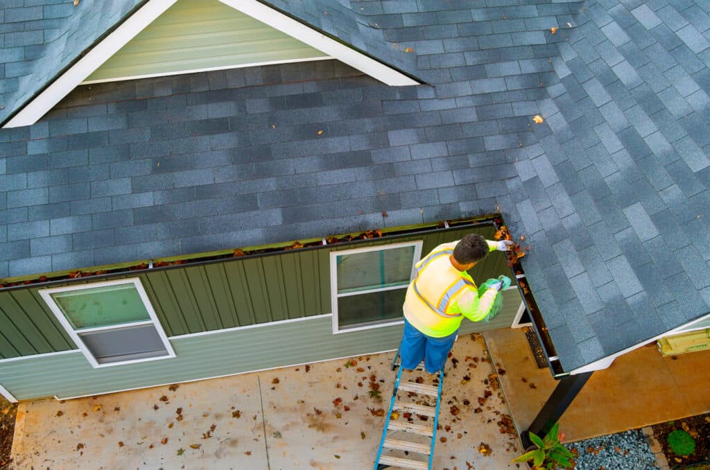 Man Cleaning Out the Gutters of His Western Colorado Home in Spring