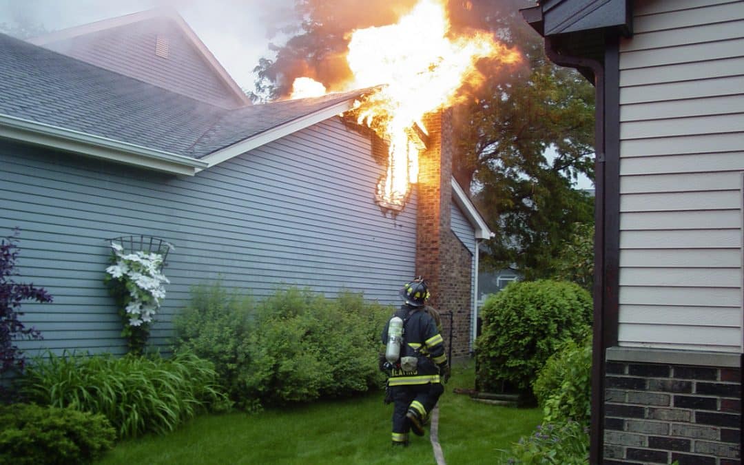 Firefighter Putting Out Home Fire Near Roof