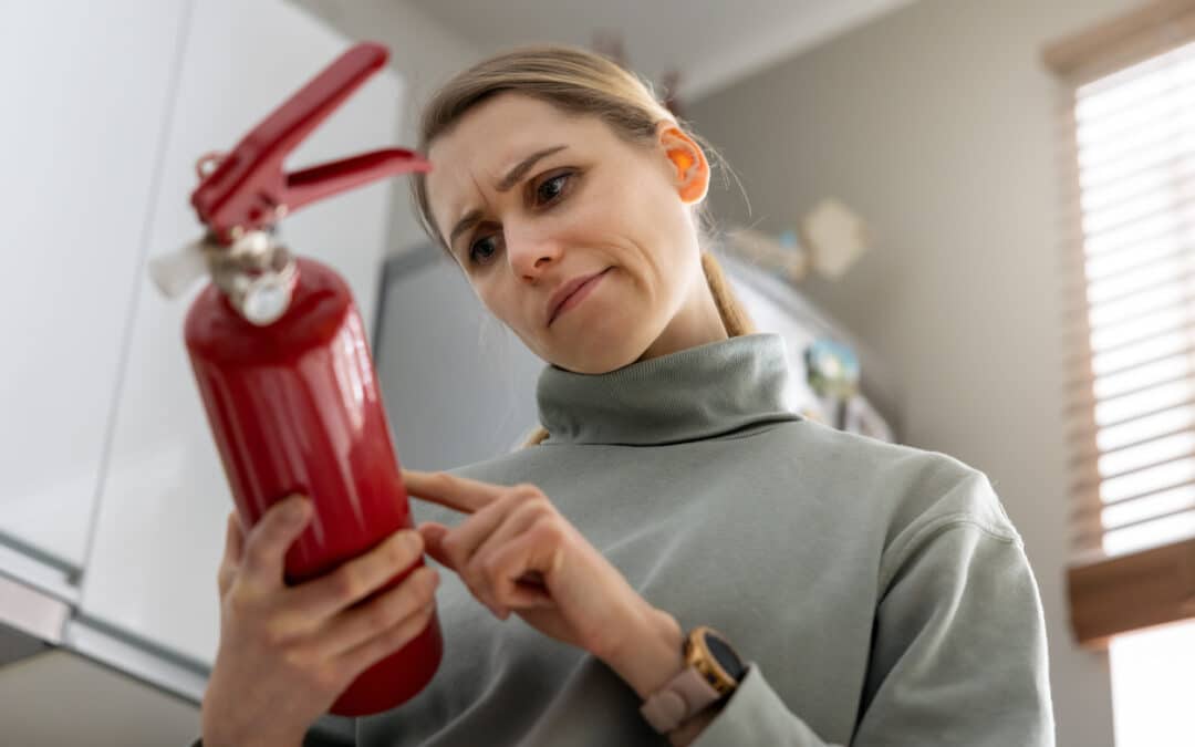 A Woman Examining A Fire Extinguisher